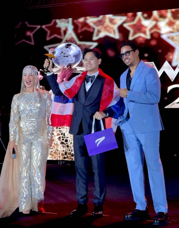 อาจารย์ทีนรับถ้วยรางวัลบนเวที พร้อมธงชาติไทย